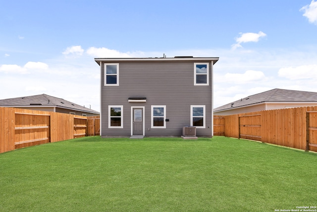 back of property with a lawn and central AC