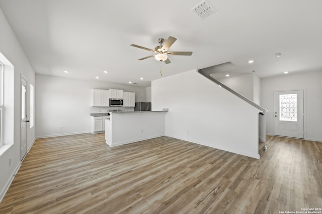 unfurnished living room with ceiling fan and light wood-type flooring