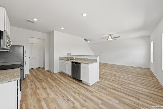 kitchen featuring light wood-type flooring, sink, white cabinets, appliances with stainless steel finishes, and light stone countertops