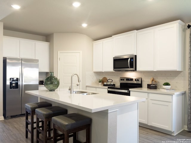 kitchen with sink, a center island with sink, white cabinets, and appliances with stainless steel finishes