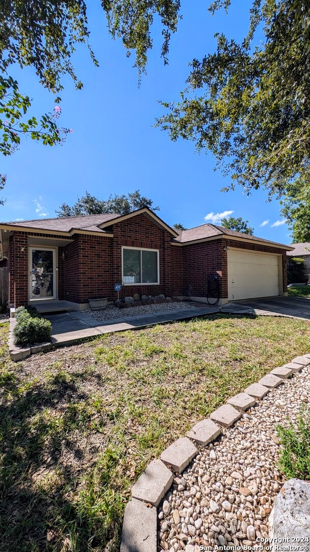 ranch-style house with a front yard and a garage