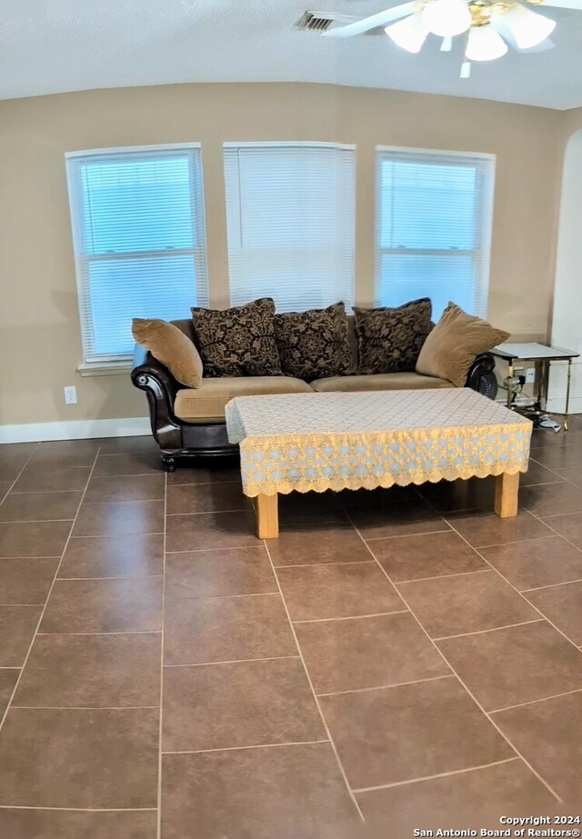 tiled living room featuring ceiling fan