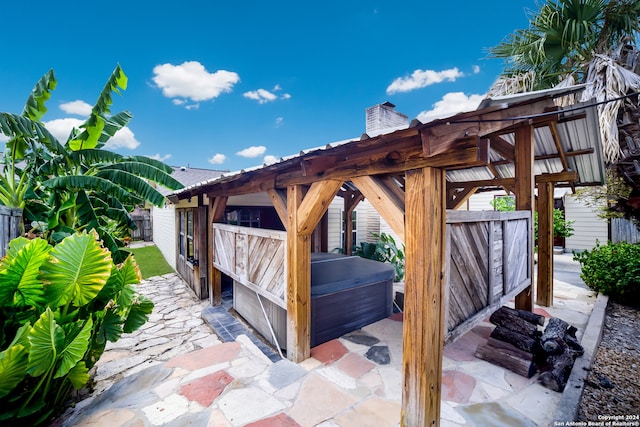 deck featuring a pergola, a patio, and a hot tub