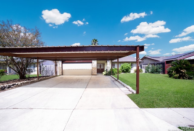 view of front of property featuring a garage, a front lawn, and a carport