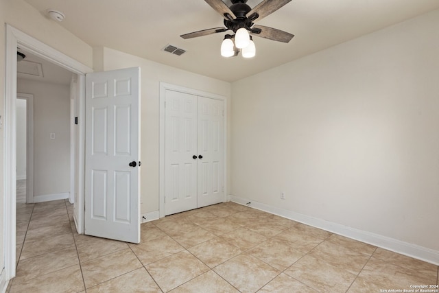 unfurnished bedroom featuring ceiling fan, a closet, and light tile patterned floors