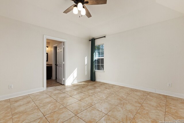 tiled spare room featuring ceiling fan