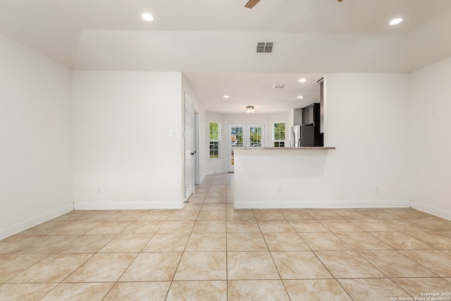 tiled spare room featuring french doors and ceiling fan