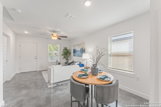 dining room with ceiling fan and concrete flooring