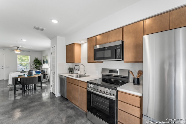 kitchen featuring ceiling fan, appliances with stainless steel finishes, sink, and tasteful backsplash