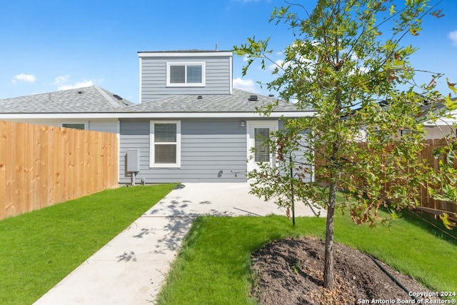 back of house featuring a patio and a yard