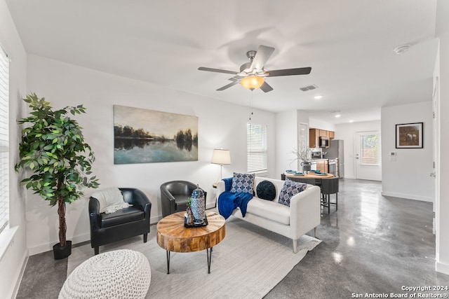 living room featuring concrete flooring and ceiling fan