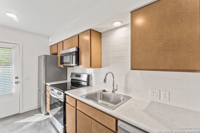 kitchen featuring stainless steel appliances, backsplash, and sink