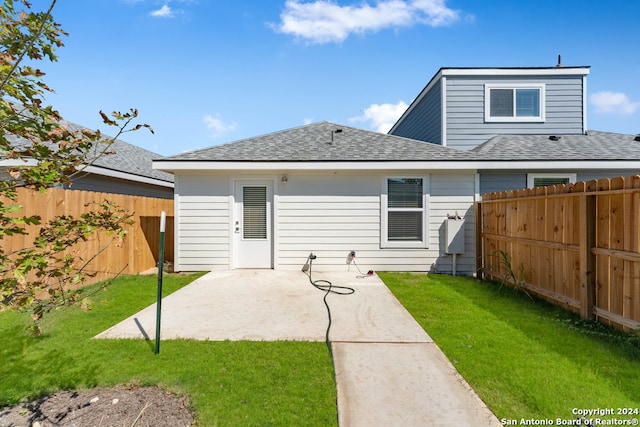 rear view of house with a lawn and a patio