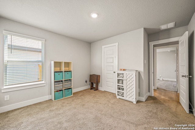 unfurnished bedroom featuring carpet and a textured ceiling