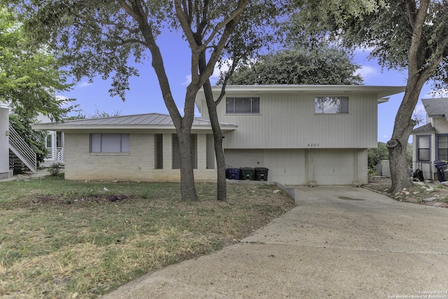 4207 High Sierra, San Antonio, TX 78228 - view of front of house with an attached garage, brick siding, concrete driveway, and metal roof