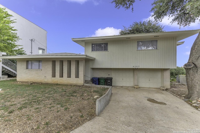 4207 High Sierra, San Antonio, TX 78228 - back of property with brick siding, a garage, and driveway