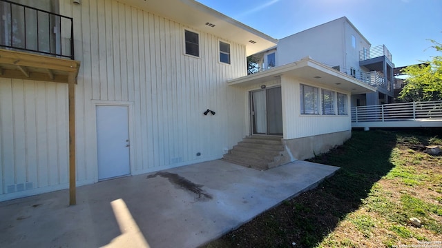 view of side of home with a patio and a balcony