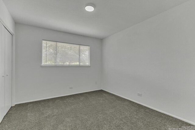 4207 High Sierra, San Antonio, TX 78228 - unfurnished bedroom featuring dark colored carpet, a closet, and baseboards
