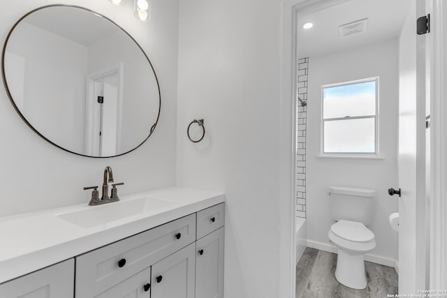 full bathroom featuring vanity, washtub / shower combination, toilet, and wood-type flooring