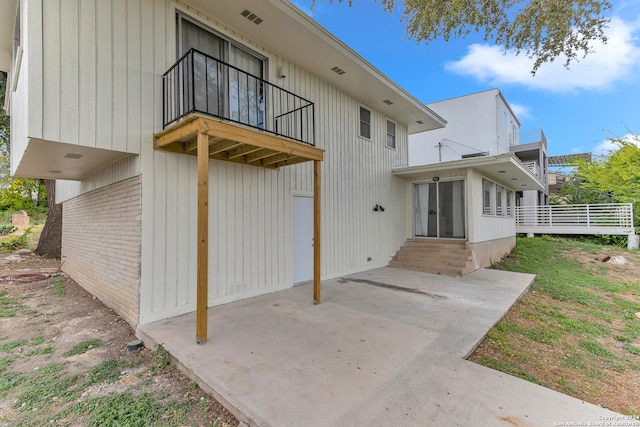 back of property with a balcony and a patio