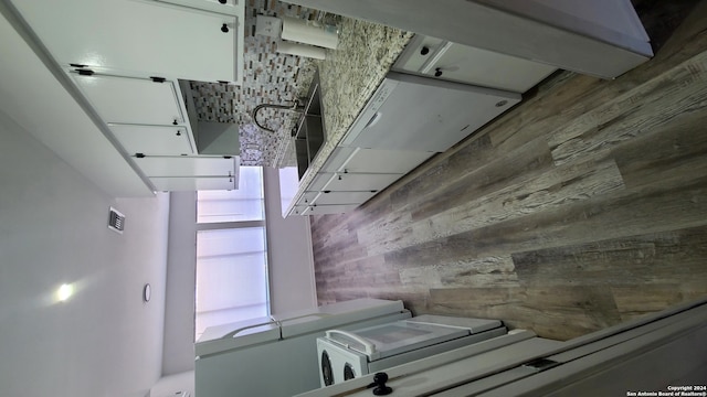 kitchen with wood-type flooring and white cabinets