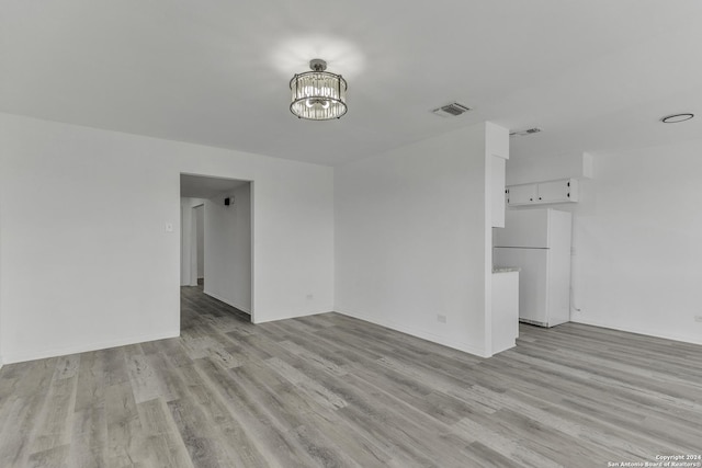 4207 High Sierra, San Antonio, TX 78228 - unfurnished living room featuring light wood-style flooring, a chandelier, and baseboards