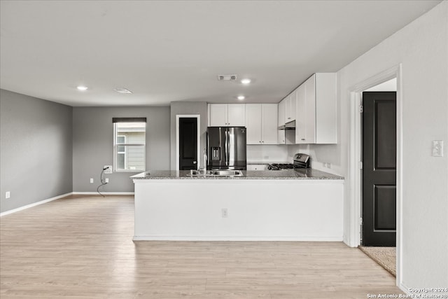 kitchen featuring white cabinets, kitchen peninsula, stone countertops, light hardwood / wood-style flooring, and stainless steel appliances