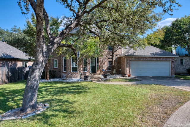 view of property hidden behind natural elements with a garage and a front lawn