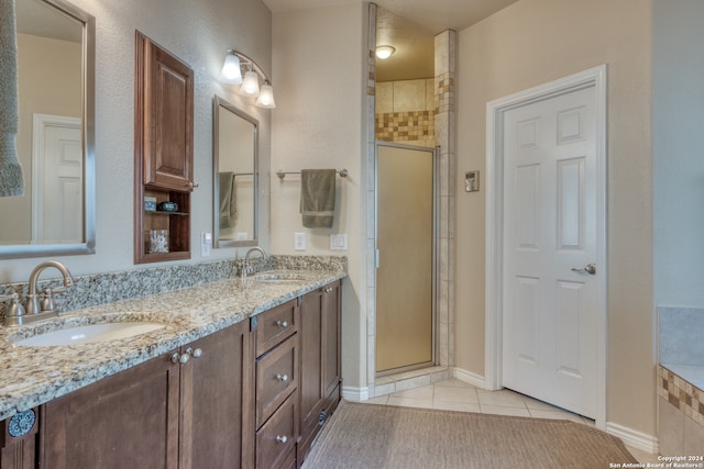 bathroom featuring vanity, tile patterned floors, and a shower with shower door