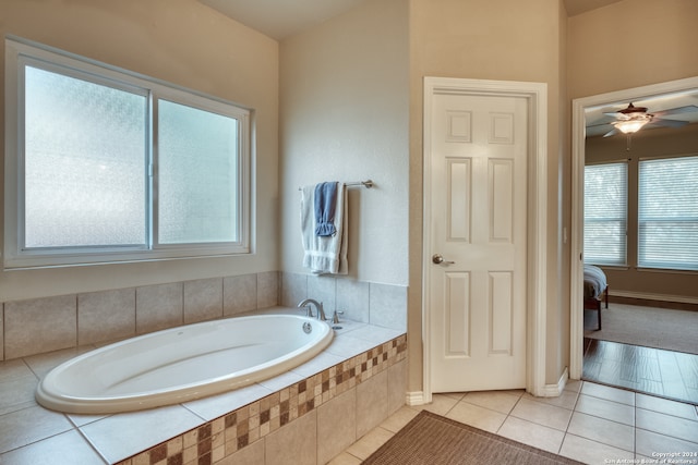 bathroom featuring tiled tub, ceiling fan, and tile patterned floors