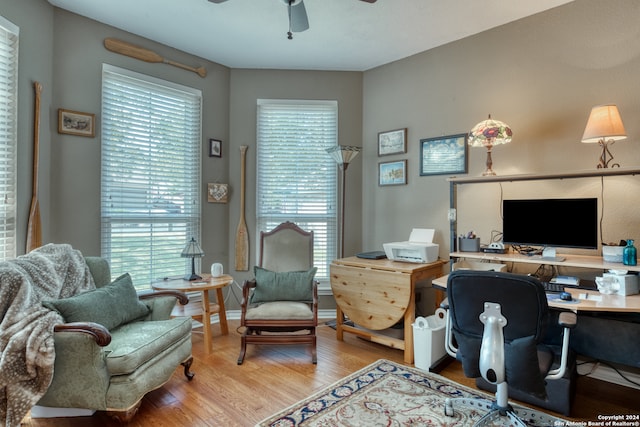 home office with wood-type flooring, ceiling fan, and a healthy amount of sunlight