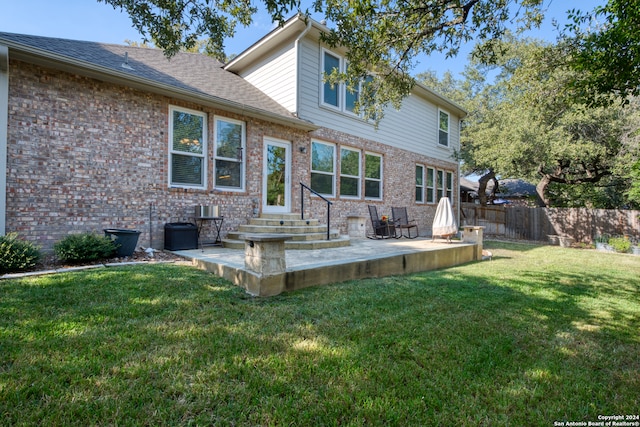 back of house featuring a lawn and a patio