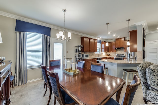 dining room with ornamental molding, a chandelier, a healthy amount of sunlight, and sink