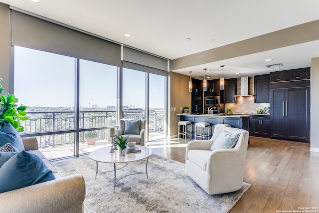 living room with sink and light hardwood / wood-style flooring