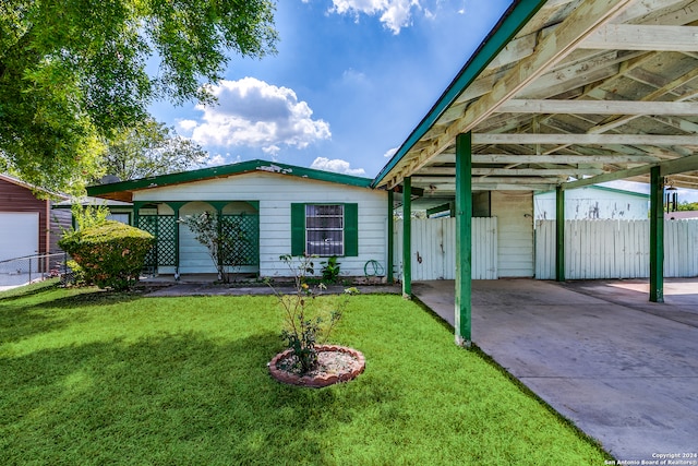 view of front of house with a carport and a front lawn