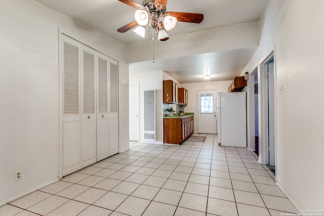 kitchen with ceiling fan, white refrigerator, and light tile patterned floors