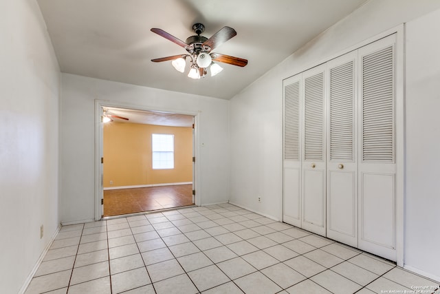 unfurnished bedroom with ceiling fan, light tile patterned flooring, and a closet