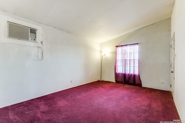 spare room featuring lofted ceiling, a wall mounted air conditioner, and carpet