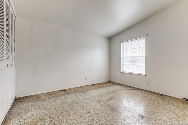 unfurnished room featuring lofted ceiling