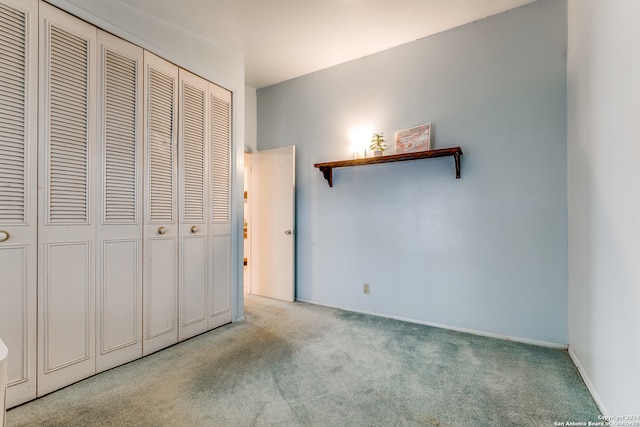 unfurnished bedroom with light colored carpet and a closet