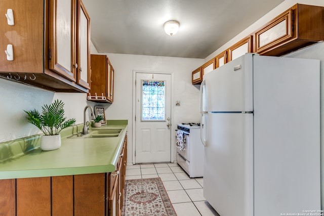 kitchen with white appliances, sink, and light tile patterned floors