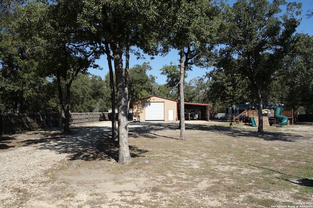 view of yard with a playground, an outdoor structure, and a garage