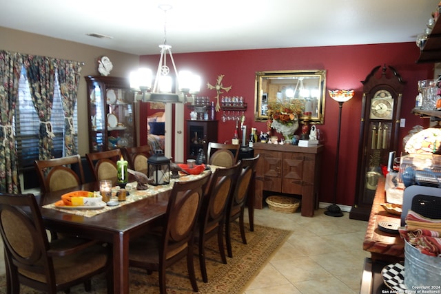 dining room with light tile patterned flooring and a notable chandelier