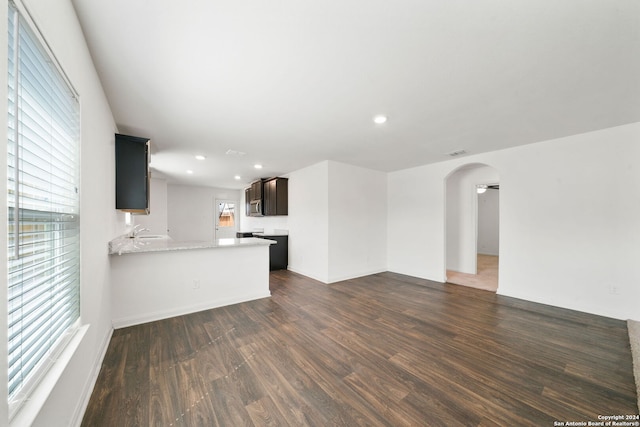 unfurnished living room with dark hardwood / wood-style floors and sink