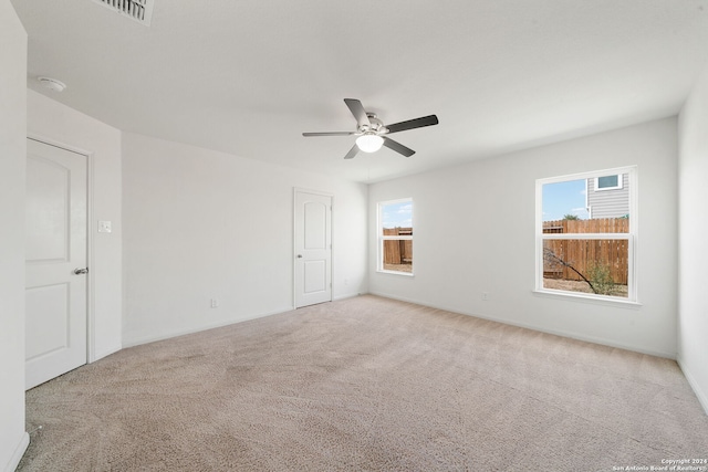 carpeted spare room with ceiling fan