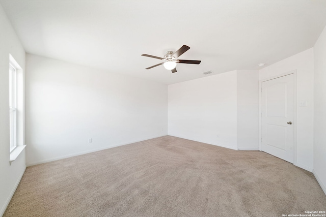 unfurnished room with ceiling fan and light colored carpet