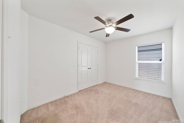 unfurnished room with ceiling fan and light colored carpet