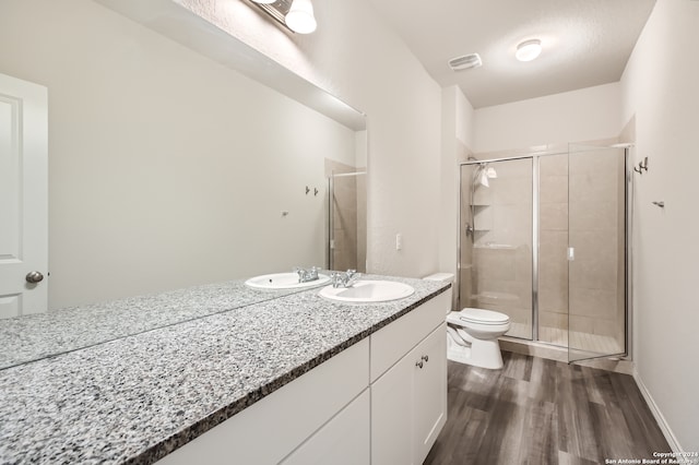 bathroom featuring vanity, toilet, an enclosed shower, and hardwood / wood-style flooring