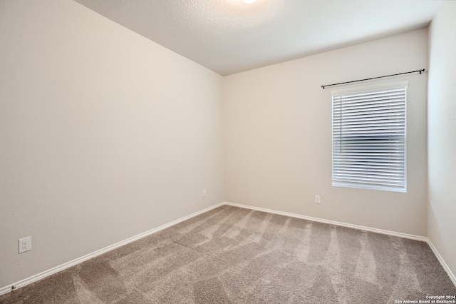 empty room with a textured ceiling and carpet