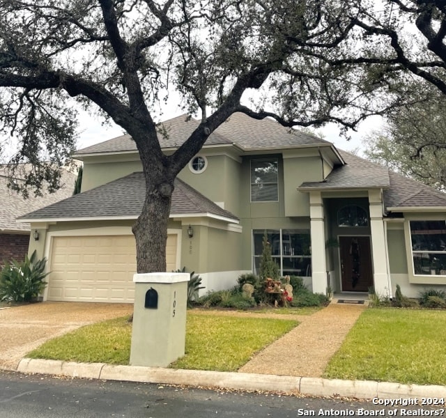 view of front of home with a front yard and a garage